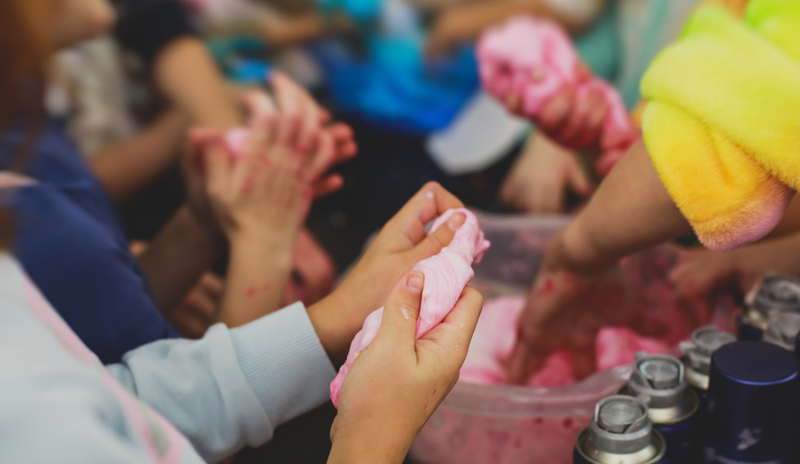 Παιδιά φτιάχνουν slime σε τραπέζι με πολύχρωμα υλικά